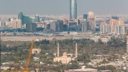 Téléchargez les photos : Vue aérienne sur Dubai Creek avec festival ville timelapse. Mosquée et gratte-ciel avec site de construction chaleureux du centre-ville. Dubaï - EAU - en image libre de droit