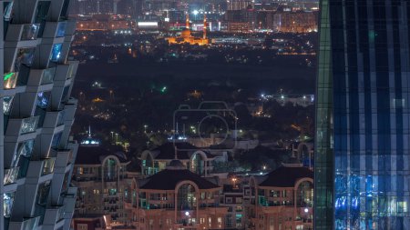 Téléchargez les photos : Vue aérienne vers le quartier Deira et Dubai Creek avec des bâtiments anciens et modernes typiques timelapse de nuit. Trafic routier. Vue entre gratte-ciel. Dubai, Émirats arabes unis - en image libre de droit