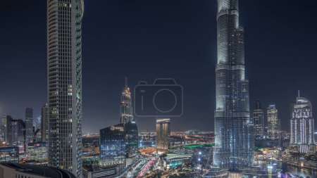 Foto de Vista panorámica del centro de Dubái con centro comercial, fuentes y timelapse nocturno aéreo Burj Khalifa. Rascacielos y torres iluminados modernos - Imagen libre de derechos