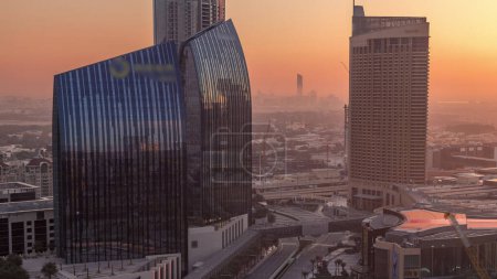 Photo for Dubai downtown street with busy traffic and skyscrapers around morning timelapse during sunrise. Modern road and urban buildings with mall aerial view. Sheikh Mohammed bin Rashid Blvd - Royalty Free Image