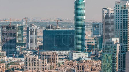 Téléchargez les photos : Dubaï gratte-ciel du centre-ville vue aérienne étonnante depuis le haut timelapse avec des maisons traditionnelles de la vieille ville, Dubaï, Émirats arabes unis. Tours modernes et chantier de construction - en image libre de droit