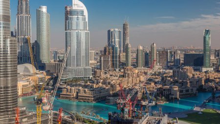 Téléchargez les photos : Dubaï gratte-ciel du centre-ville vue aérienne incroyable à timelapse du soir avec fontaines, Dubaï, Émirats arabes unis. Tours modernes et chantier de construction. Ciel bleu nuageux - en image libre de droit
