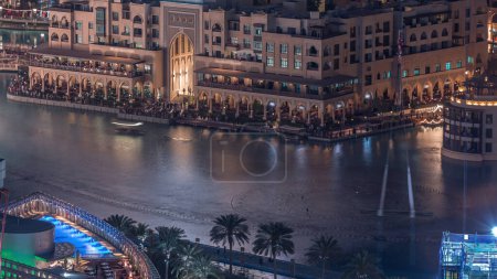 Photo for Unique view of Dubai Fountains pool at night timelapse. Tourist attraction. Aerial view with Old Town Island from above and souk - Royalty Free Image