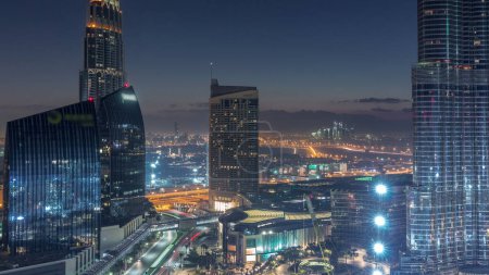 Dubaï rue du centre-ville avant le lever du soleil avec la circulation achalandée et gratte-ciel autour de nuit au jour. Bâtiments routiers et urbains modernes avec vue aérienne du centre commercial avec brume matinale. Cheikh Mohammed bin Rashid Blvd