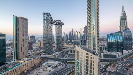 Téléchargez les photos : Vue aérienne de bâtiments neufs et hauts avec des routes achalandées timelapse. Transition du jour à la nuit à Dubaï Centre-ville d'en haut, Dubaï, Émirats arabes unis - en image libre de droit