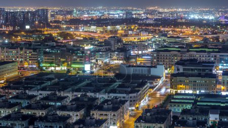 Téléchargez les photos : Vue aérienne du quartier Deira et du ruisseau Dubaï avec des bâtiments anciens et modernes typiques timelapse de nuit. Aéroport sur un fond. Vue depuis le toit du gratte-ciel. Dubai, Émirats arabes unis - en image libre de droit
