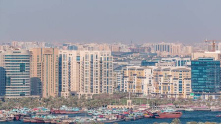 Téléchargez les photos : Vue aérienne du quartier Deira et Dubai Creek avec des bâtiments typiques anciens et modernes timelapse. Bateaux et boutres traditionnels. Vue depuis le toit du gratte-ciel. Dubai, Émirats arabes unis - en image libre de droit