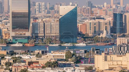 Foto de Vista aérea del barrio de Deira y Dubai arroyo con edificios típicos antiguos y modernos timelapse. Sharjah en un segundo plano. Vista desde la azotea del rascacielos. Dubai, Emiratos Árabes Unidos - Imagen libre de derechos