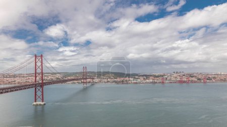 Panorama showing Lisbon cityscape with landmark suspension 25 of April bridge and Tagus river timelapse, aerial view of Old Town Alfama from viewpoint of Cristo Rei in Almada. Portugal