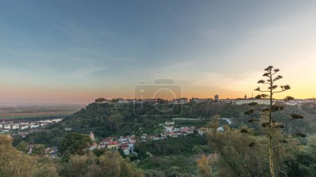 Foto de Panorama que muestra la puesta de sol sobre el castillo de Almourol en la colina en Santarem timelapse aéreo. Un castillo medieval sobre el islote de Almourol en medio del río Tajo y casas. Portugal - Imagen libre de derechos