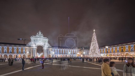 Photo for Panorama showing Commerce square illuminated arch and decorated at Christmas time in Lisbon night timelapse. Commercio square with Christmas tree and people crowd around. Holiday times. Portugal - Royalty Free Image