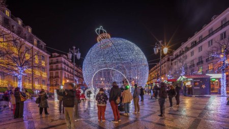 Téléchargez les photos : Panorama montrant les décorations de Noël avec grand ballon sur la place Luis De Camoes (Praca Luis de Camoes) timelapse de nuit. L'une des plus grandes places de Lisbonne au Portugal illuminée dans la soirée - en image libre de droit