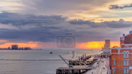 Photo for Sunset panoramic view of the Padrao dos Descobrimentos (Monument to the Discoveries) timelapse. Famous monument on the banks of the River Tagus in Lisbon with dark clouds and rain on background. - Royalty Free Image