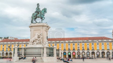 Téléchargez les photos : Bronze statue of King Jose I at Commerce square timelapse in Lisbon, Portugal. Cloudy sky behind yellow building - en image libre de droit