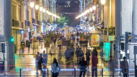 Téléchargez les photos : La rue Augusta bondée vue à travers l'arc triomphal timelapse de nuit reliant la rue la plus célèbre de Lisbonne à Terreiro do Paco Square aka Praca do Comercio. - en image libre de droit