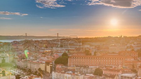 Téléchargez les photos : Lisbonne au coucher du soleil vue panoramique aérienne du centre-ville avec des toits rouges à Timelapse soirée d'automne, Portugal. Pont sur un fond. Vue de dessus depuis le point de vue Miradouro da Nossa Senhora do Monte - en image libre de droit
