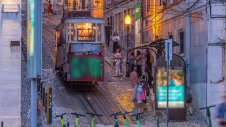 Foto de Gloria funicular de Lisboa día a noche timelapse transición situado en el lado oeste de la Avenida da Liberdade conecta el centro de la ciudad con Bairro Alto. Está clasificado como monumento nacional inaugurado en 1885. - Imagen libre de derechos