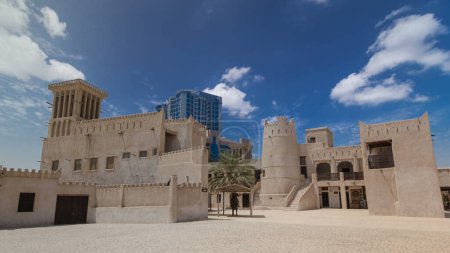 Téléchargez les photos : Fort historique au Musée d'Ajman hyperlapsus timelapse avec ciel bleu, Émirats arabes unis. Tour moderne sur fond - en image libre de droit
