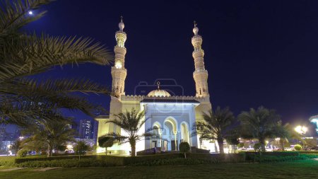 Photo for Al Noor Mosque in Sharjah at night with moon timelapse hyperlapse. United Arab Emirates. Park with palms - Royalty Free Image