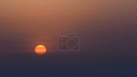 Große Sonne am orangen Himmel. Sonnenaufgang mit Stadtbild von Ajman aus der Luft. Ajman ist die Hauptstadt des Emirats Ajman in den Vereinigten Arabischen Emiraten.