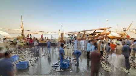 Foto de Marisco en el mercado de pescado en el emirato de Ajman timelapse. Los pescadores venden muchos tipos de peces cerca de barco en la orilla - Imagen libre de derechos