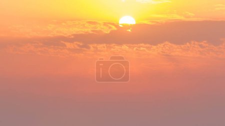 Foto de Puesta de sol en Ajman vista aérea desde timelapse azotea. Vista nocturna del sol en el cielo nublado de color naranja en los Emiratos Árabes Unidos. Líneas eléctricas sobre fondo - Imagen libre de derechos