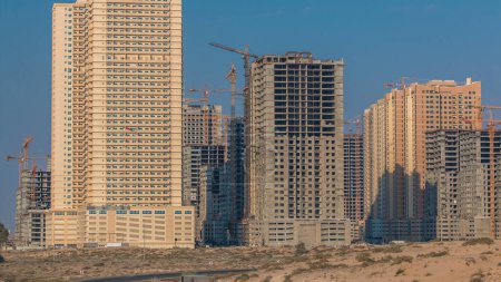 Foto de Moderna obra de construcción de nuevas torres en Ajman timelapse. Paisaje urbano de Ajman. Ajman es la capital del emirato de Ajman en los Emiratos Árabes Unidos. - Imagen libre de derechos