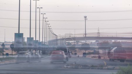 Photo for Highway roads in desert with busy traffic timelapse in a big city from Ajman to Dubai at evening from bridge. Transportation concept. - Royalty Free Image