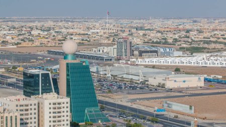 Foto de Paisaje urbano de Ajman desde la azotea con edificios modernos y timelapse de tráfico. Muchos coches en el estacionamiento cerca del supermercado en los Emiratos Árabes Unidos. - Imagen libre de derechos