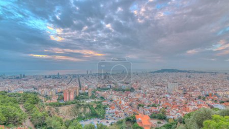 Téléchargez les photos : Panorama de Barcelone pendant le lever du soleil timelapse, Espagne, vue depuis les bunkers du Carmel par une matinée nuageuse avec des rayons de lumière. Vue aérienne depuis la colline. Ciel coloré - en image libre de droit