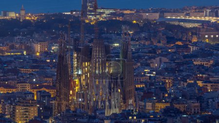 Foto de Barcelona 's Morning: Night to Day Timelapse Panorama de la cautivadora ciudad de España. Vista aérea desde los bunkers del Carmelo, Catedral de la Sagrada Familia, mientras las luces de la ciudad se atenúan con gracia antes del amanecer - Imagen libre de derechos