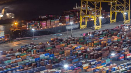 Photo for Night Timelapse of Barcelona's Seaport and Loading Docks. Aerial View from Montjuic Hill Showcases Illuminated Cranes and Multi-Colored Cargo Containers, Painting Port with a Dazzling Glow - Royalty Free Image