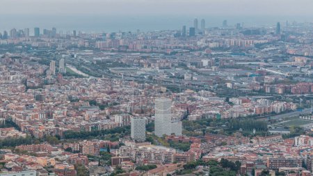 Foto de Evening Timelapse de Barcelona y Badalona Skylines. Vista aérea desde el mirador Iberic Puig Castellar Village, espectacular panorámica con tejados de casas, un río serpenteante y vasto mar en horizonte - Imagen libre de derechos