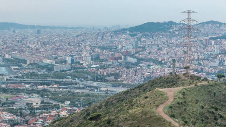 Evening Timelapse of Barcelona and Badalona Skylines. Aerial View from Iberic Puig Castellar Village Viewpoint, Revealing Roofs of Houses and the Sea on the Horizon, Creating a Picturesque Panorama