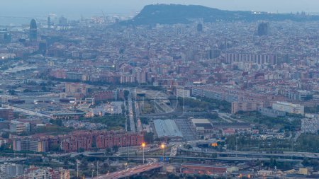 Tag-Nacht-Übergangszeit von Barcelona und Badalona Skylines. Luftaufnahme vom iberischen Dorf Puig Castellar, Aufnahme der Straßenkreuzung und des allmählichen Übergangs vom Sonnenuntergang zur Nacht