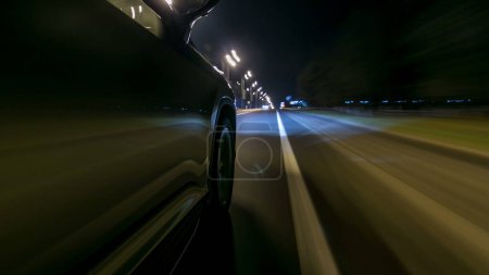 Photo for Driving at high speed through the streets timelapse drivelapse hyperlapse. View from side of car with slider movement at night city road - Royalty Free Image