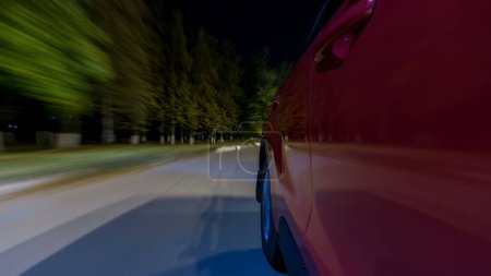 Foto de Drivelapse from Side of Car moving on a night highway timelapse hyperlapse, carretera con luces reflejadas en el coche a alta velocidad. Ritmo rápido de una ciudad moderna. Movimiento borroso - Imagen libre de derechos