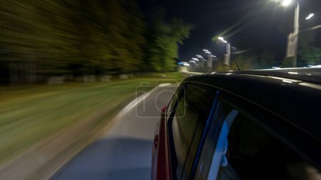 Téléchargez les photos : Drivelapse de côté de la voiture se déplaçant sur une autoroute de nuit timelapse hyperlapse, route avec des lumières réfléchies sur la voiture à grande vitesse. Rythme rapide d'une ville moderne. Mouvement flou - en image libre de droit