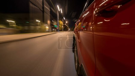 Photo for Drivelapse from side of fast car moving on a night avenue in a city timelapse hyperlapse, road with lights reflected on car at high speed. Rapid rhythm of a modern city. Blurred motion - Royalty Free Image