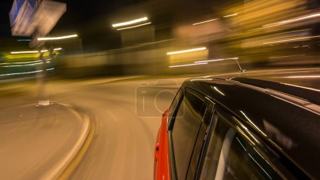 Photo for Drivelapse from side of fast car moving on a night avenue in a city timelapse hyperlapse, road with lights reflected on car at high speed. Rapid rhythm of a modern city. Blurred motion - Royalty Free Image