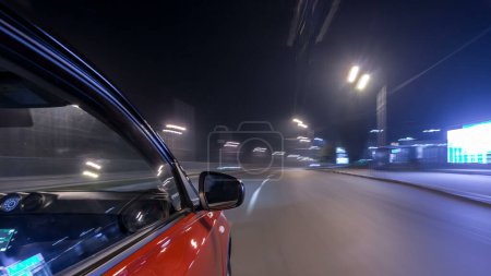 Photo for Drivelapse urban look from fast driving car at a night avenue in a city timelapse hyperlapse, road with lights reflected on car at high speed. Rapid rhythm of a modern city. Blurred motion - Royalty Free Image