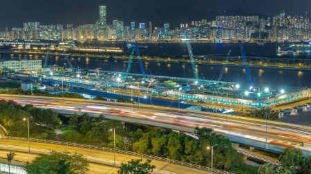 Téléchargez les photos : Hong Kong nuit, vue aérienne de kowloon Bay timelapse du centre-ville avec la circulation sur la route et le processus de construction depuis le toit, horizon de la ville sur le fond - en image libre de droit