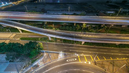 Photo for Top looking down view of Kowloon busy traffic night on the road intersecrtion with overpass timelapse, hong kong city rooftop. - Royalty Free Image