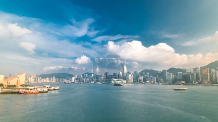 Photo for Hong Kong Harbor panorama with cityscape timelapse. Blue cloudy sky - Central District, Victoria Harbor, Victoria Peak, Hong Kong Island and Kowloon, Hong Kong. - Royalty Free Image