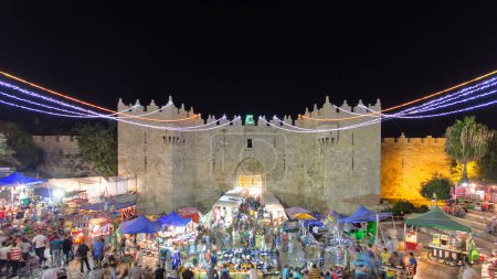 Téléchargez les photos : Porte de Damas ou Porte de Sichem timelapse de nuit, l'une des portes de la vieille ville de Jérusalem, Israël. Foule de personnes près de l'entrée - en image libre de droit