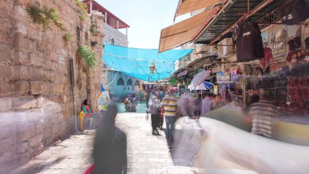 Foto de El colorido zoco en la antigua ciudad de Jerusalén Israel timelapse hiperlapso. Multitud de personas que pasan por este makret en la sombra debajo de la tienda - Imagen libre de derechos