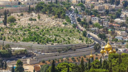 Téléchargez les photos : Le plus grand cimetière juif du monde sur les pentes intemporelles du Mont des Oliviers, Jérusalem, Israël. Circulation sur la route et église orthodoxe - en image libre de droit