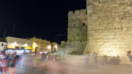 Foto de Torre de David hiperlapso del timelapse nocturno. Murallas iluminadas en el casco antiguo de Jerusalén, Israel. Gente caminando por las calles - Imagen libre de derechos