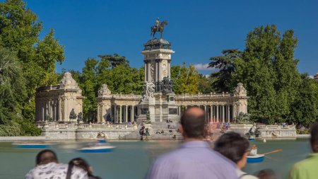 Photo for Tourists on boats at Monument to Alfonso XII timelapse hyperlapse in the Parque del Buen Retiro - Park of the Pleasant Retreat in Madrid, Spain - Royalty Free Image