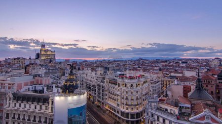 Photo for Panoramic aerial view of Gran Via day to night transition, main shopping street in Madrid Skyline Old Town Cityscape, Metropolis Building lights turn on, capital of Spain, Europe. - Royalty Free Image